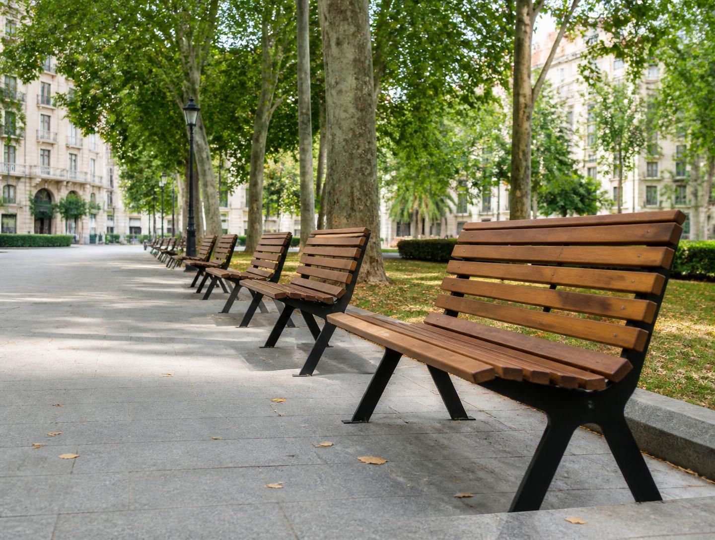 Banco urbano de acero verde y madera técnica en una plaza europea