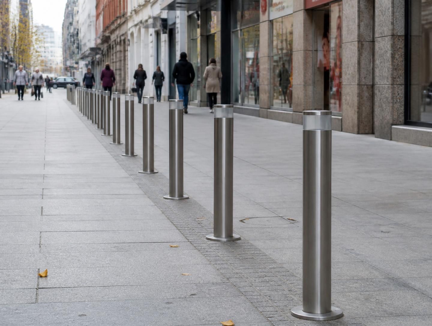 Bolardos urbanos de acero verde protegiendo una calle peatonal