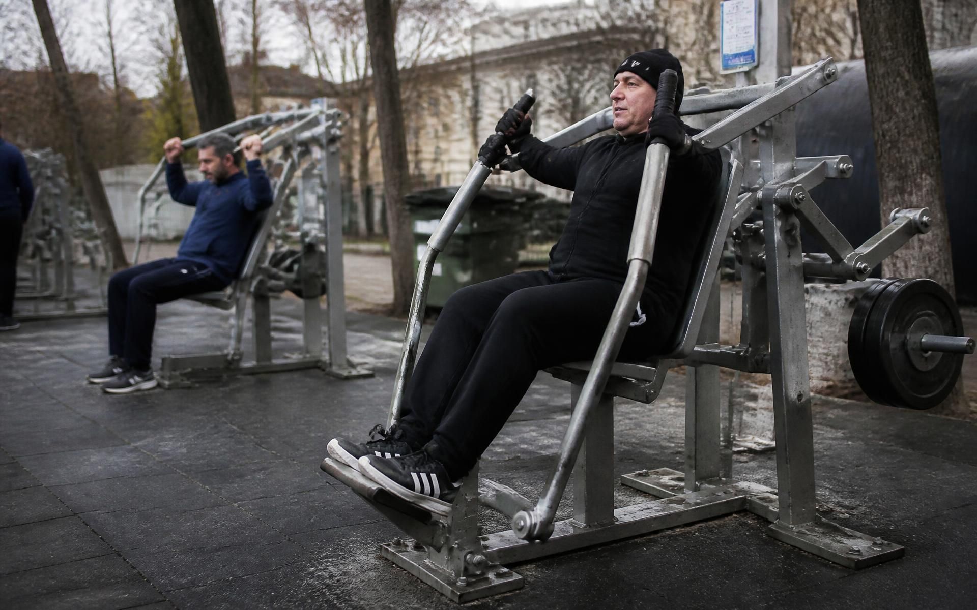 Estaciones de fitness exterior en acero verde y madera técnica en un paseo marítimo
