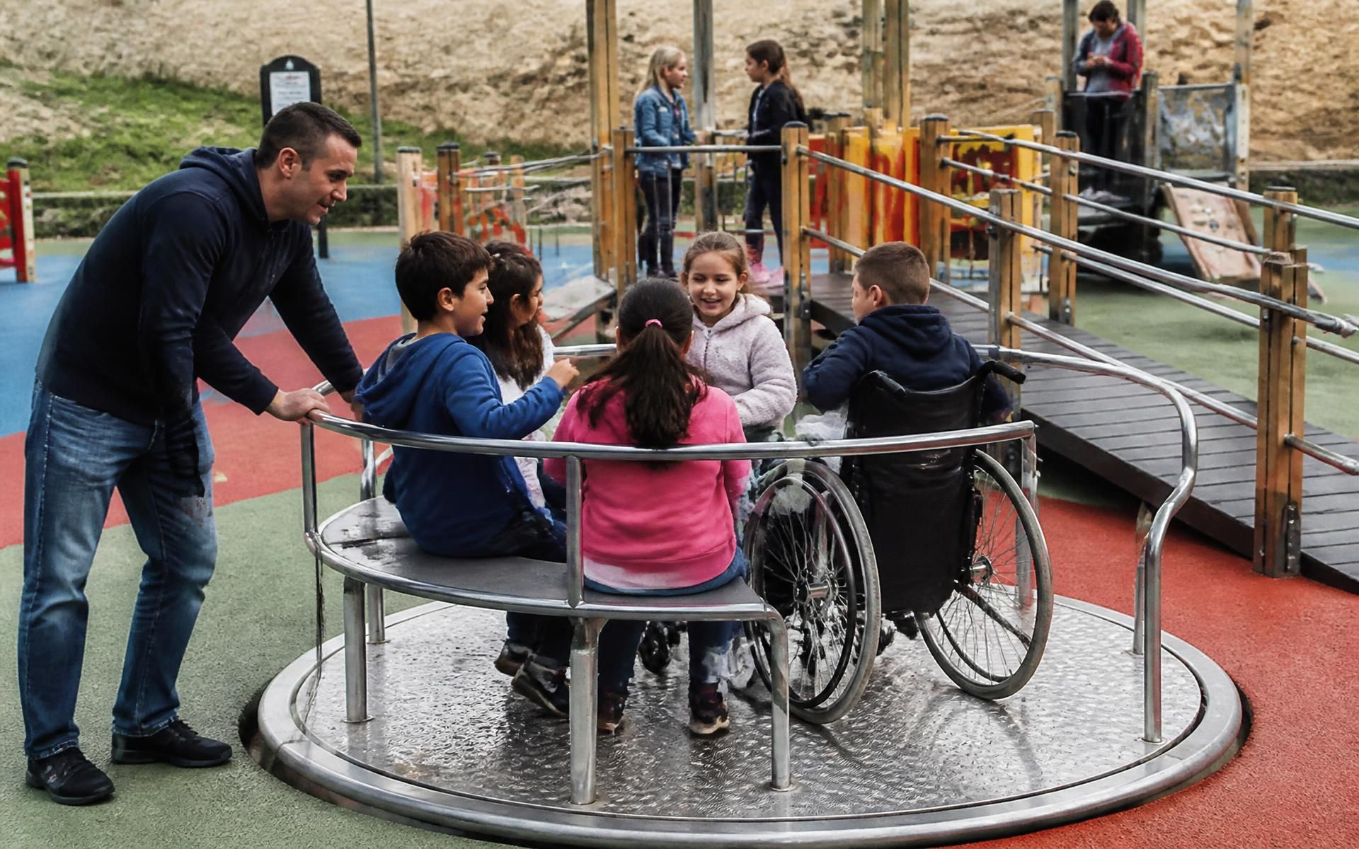 Carrusel accesible y plataforma con rampa en un área de juego inclusiva