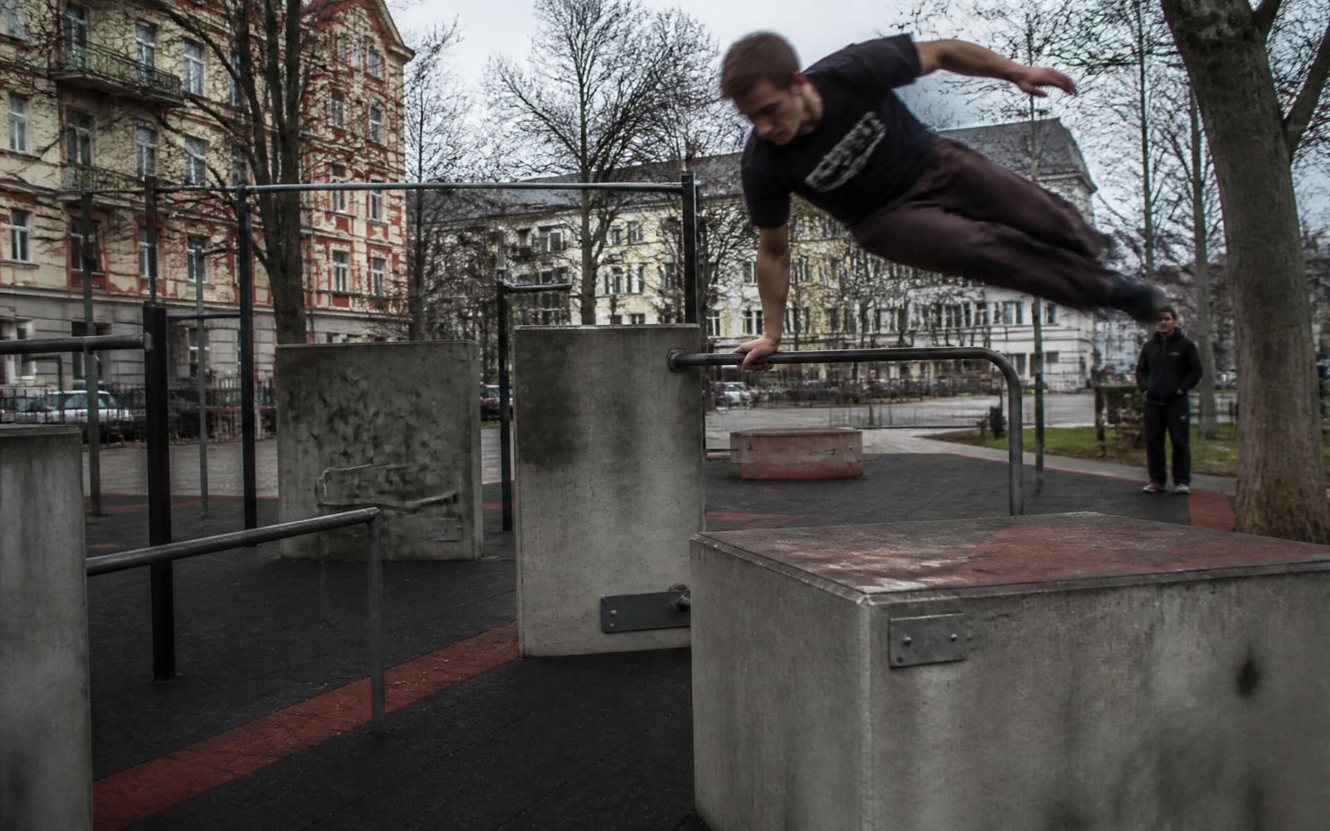 Módulos de parkour de hormigón y barras de acero verde sobre superficie amortiguadora