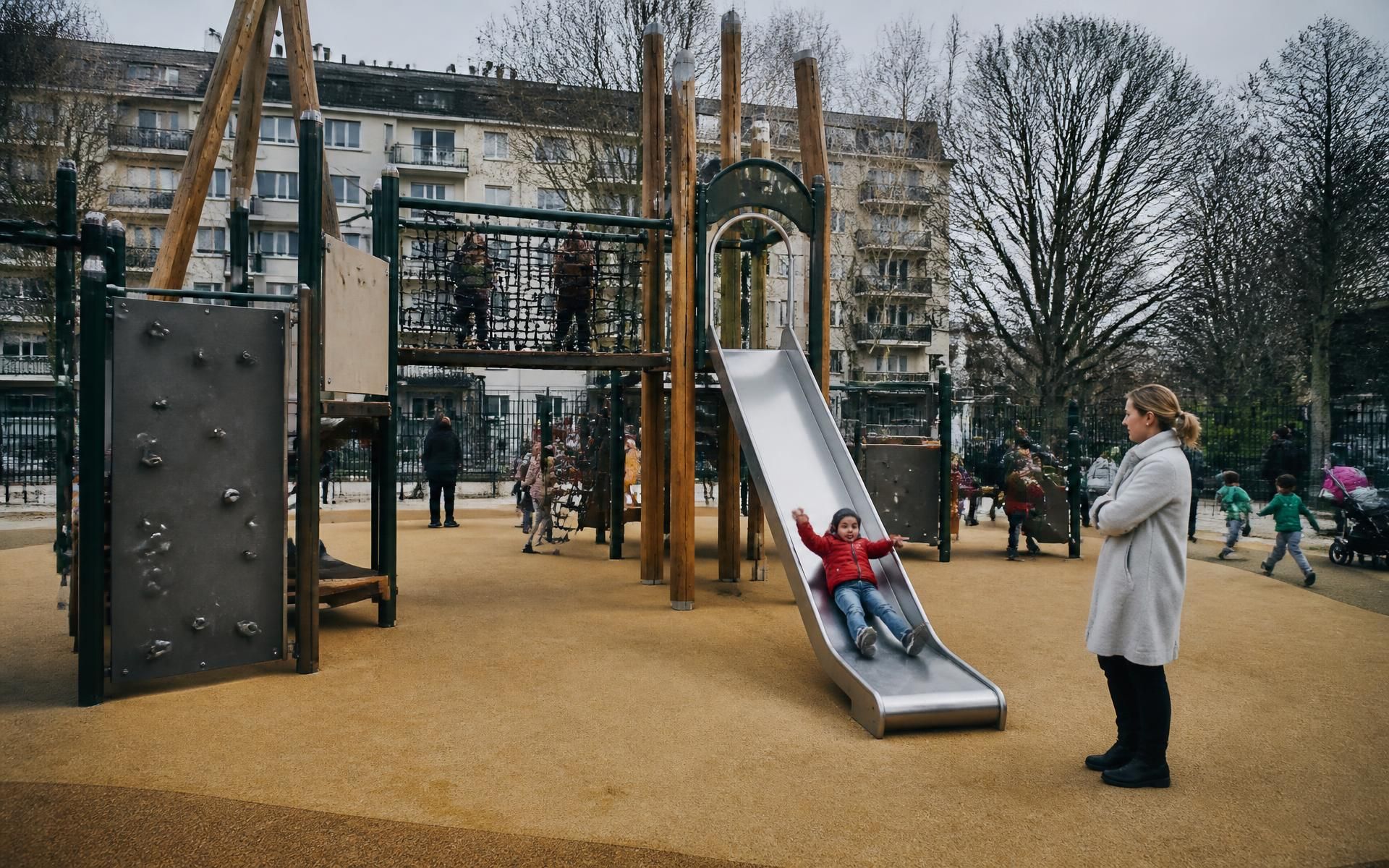 Área de juego infantil con estructura de acero verde, madera y pavimento continuo